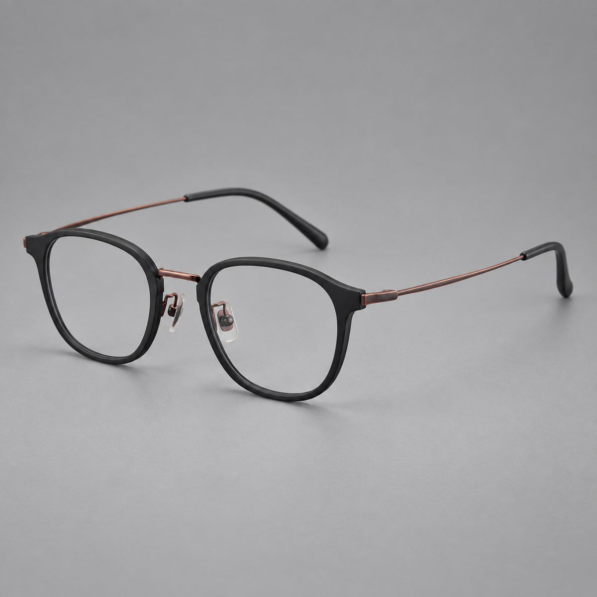 Retro soft square eyeglasses in acetate and titanium with a curved bridge and slender temples in Matte Black / Antique Copper, three quarter view