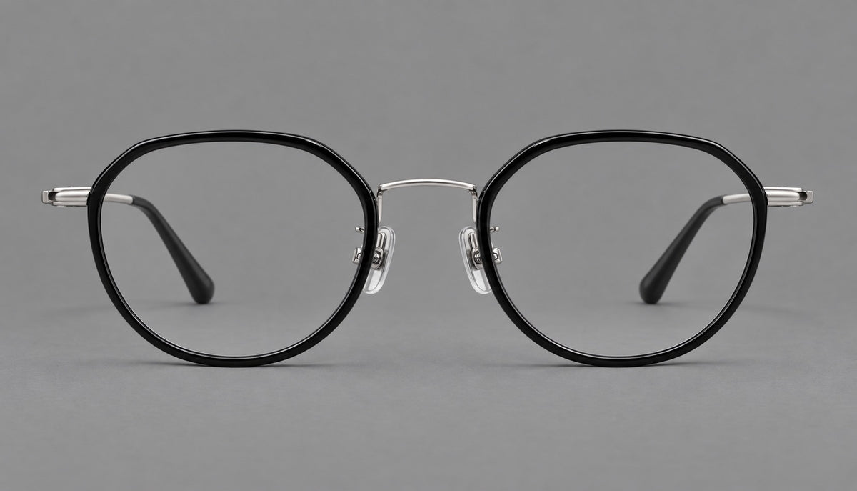 Rounded eyeglasses in acetate and titanium with gently arched brows and engraved metal temples in Black / Silver, front view