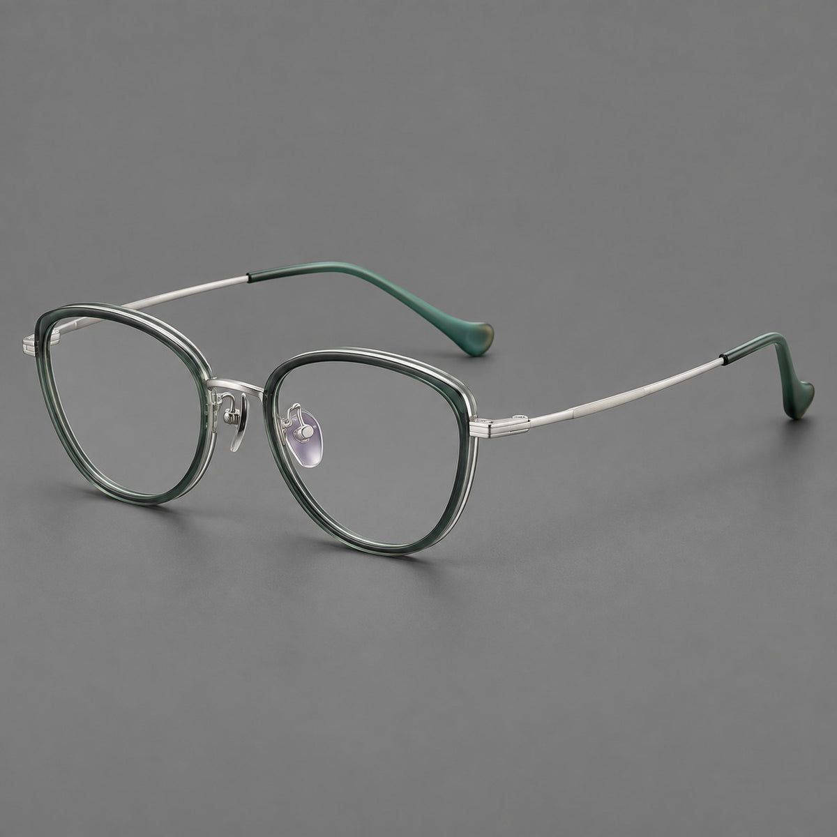 Upswept eyeglasses in acetate and titanium with softly rounded rims and tapered metal temples in Clear Green / Silver, three quarter view
