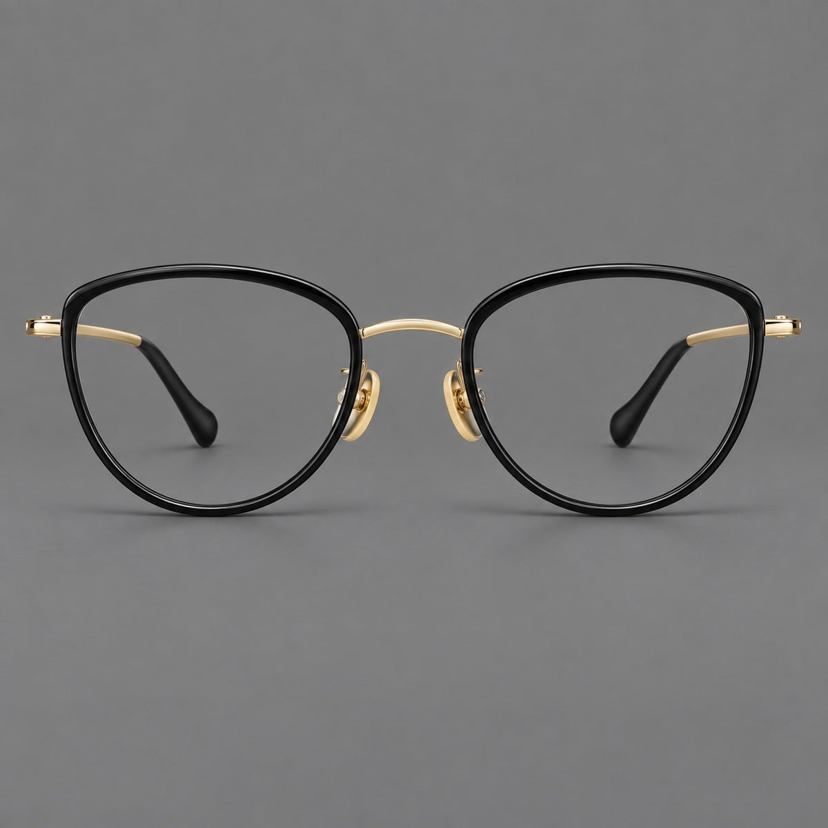 Upswept eyeglasses in acetate and titanium with softly rounded rims and tapered metal temples in Black / Gold, front view