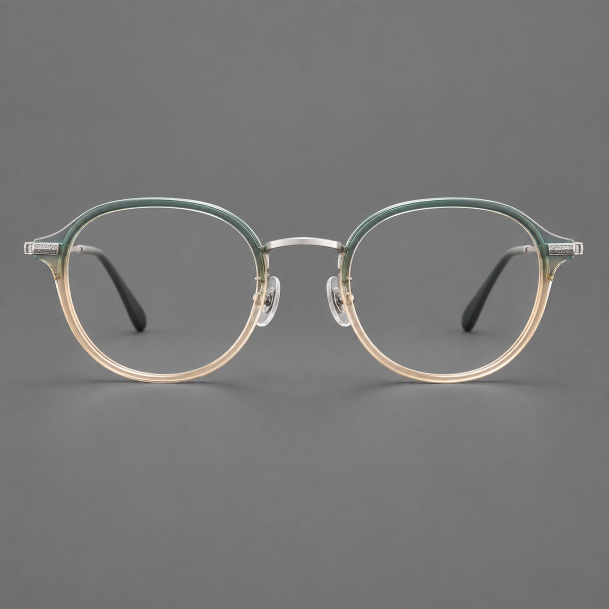 Softly rounded eyeglasses in acetate and titanium with a curved bridge and engraved temples in Green Tea Gradient / Silver, front view