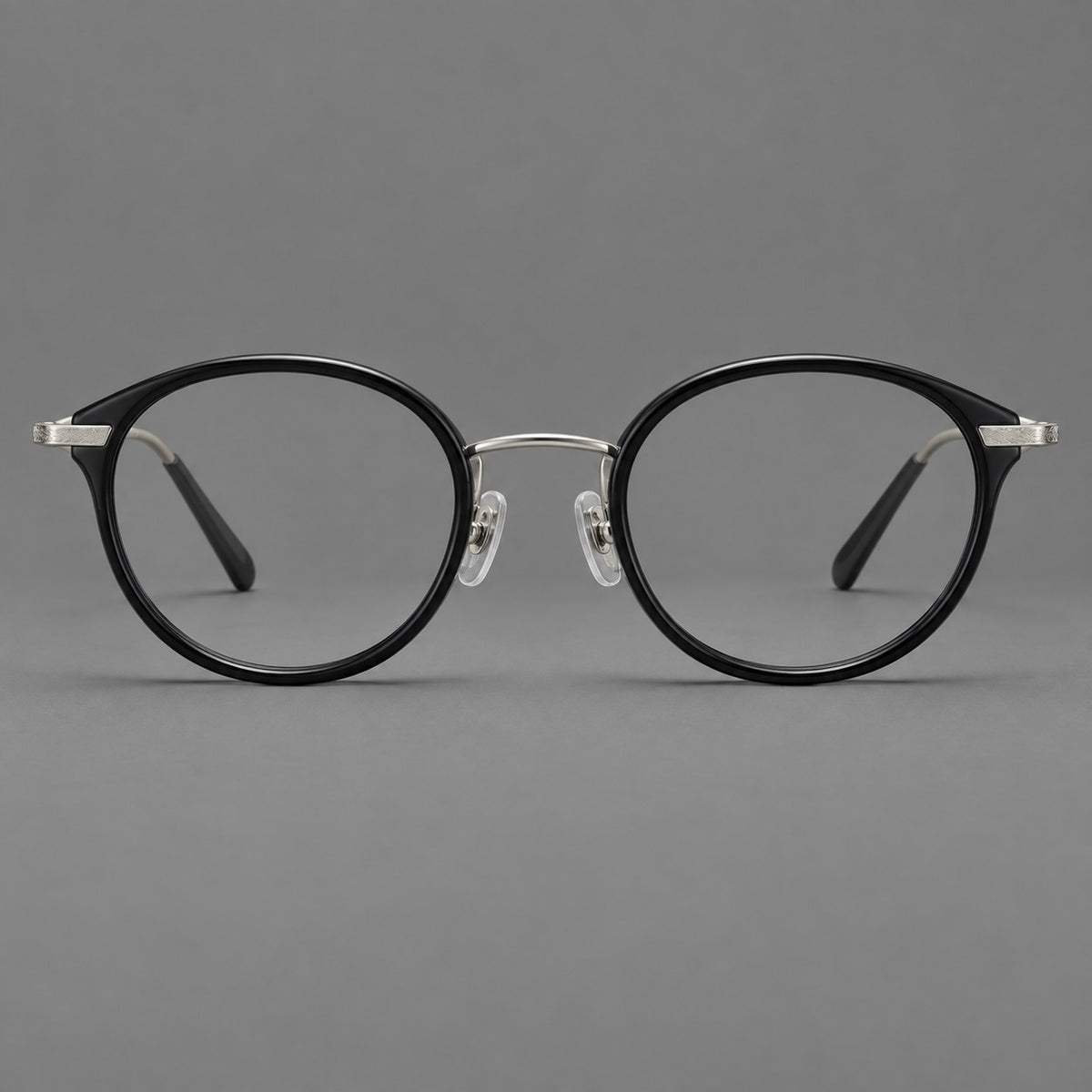 Retro panto eyeglasses in acetate and titanium with an arched bridge and engraved metal temples in Glossy Black / Matte Gunmetal, front view