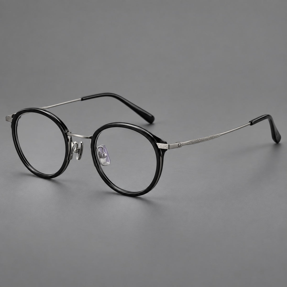 Retro panto eyeglasses in acetate and titanium with an arched bridge and engraved metal temples in Glossy Black / Matte Gunmetal, three quarter view