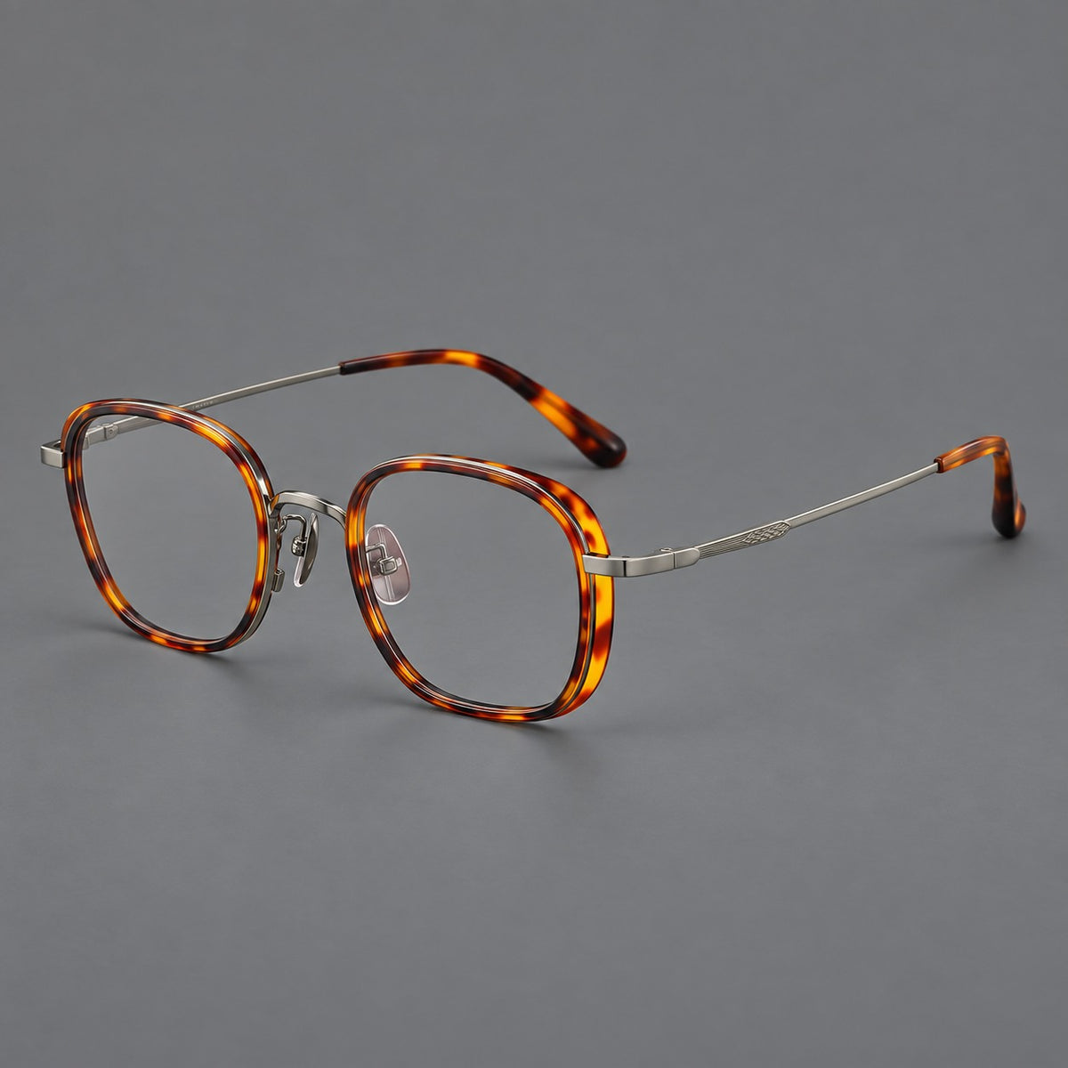 Rounded square eyeglasses in acetate and titanium with an arched bridge and engraved temples in Amber Tortoiseshell / Gunmetal, three quarter view