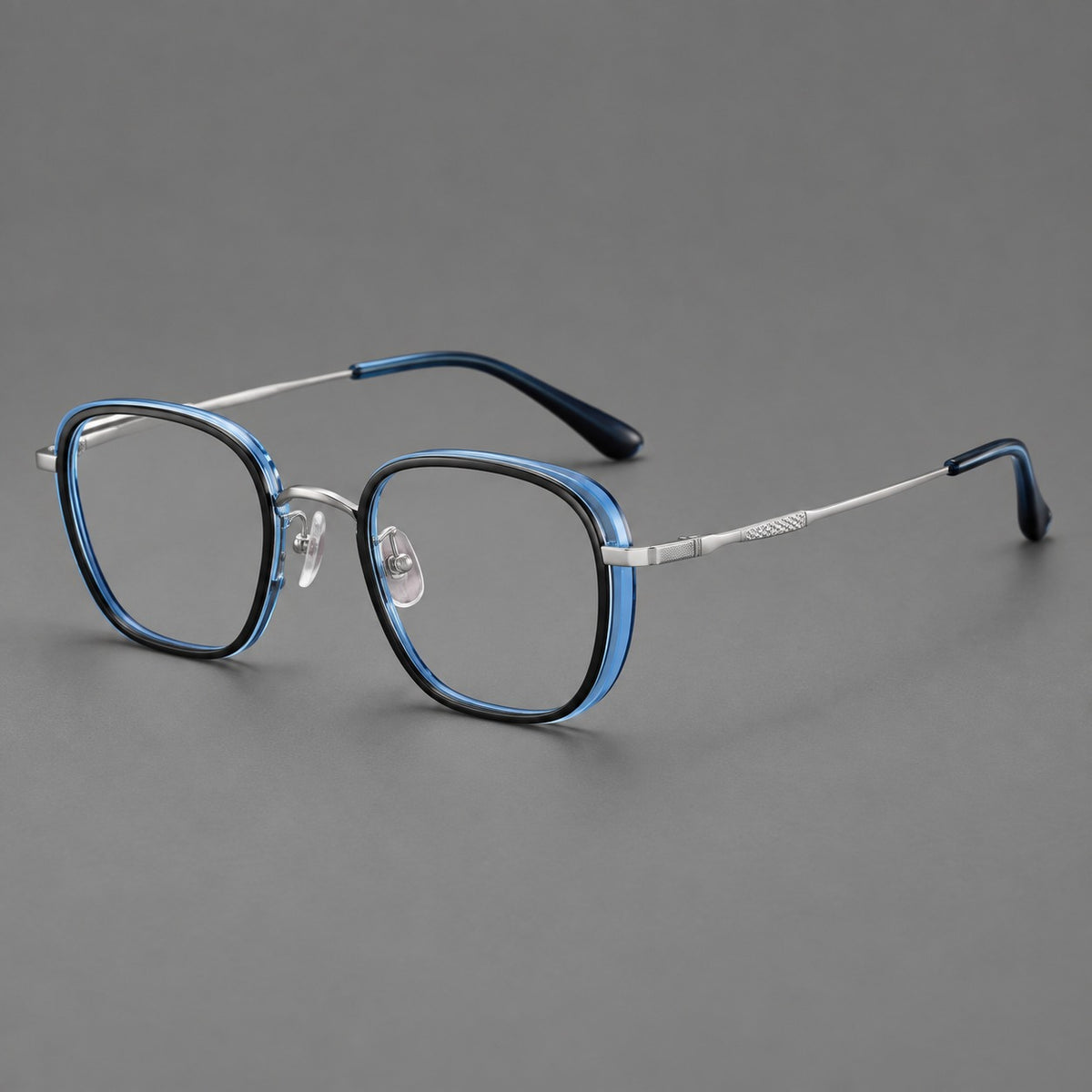 Rounded square eyeglasses in acetate and titanium with an arched bridge and engraved temples in Black and Clear Blue / Silver, three quarter view