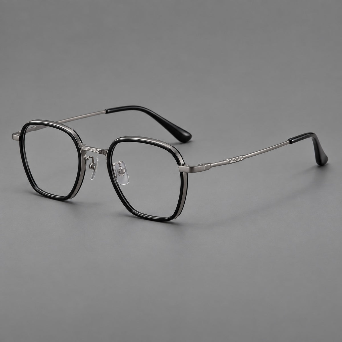 Soft square eyeglasses in acetate and titanium with slim rims and a finely engraved metal bridge in Glossy Black / Gunmetal, three quarter view