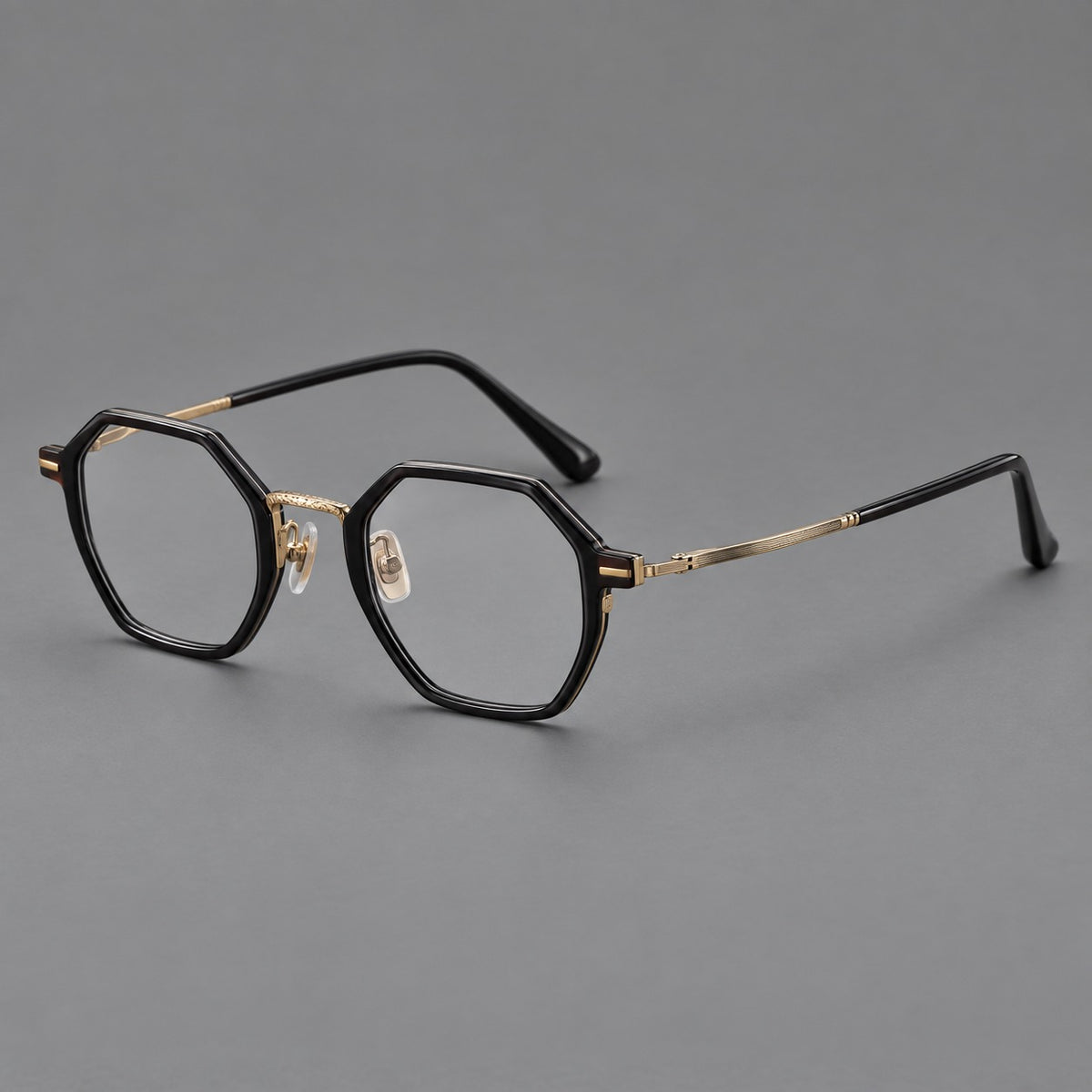 Geometric eyeglasses in acetate and titanium with octagonal rims and a textured metal bridge in Glossy Black / Antique Gold, three quarter view