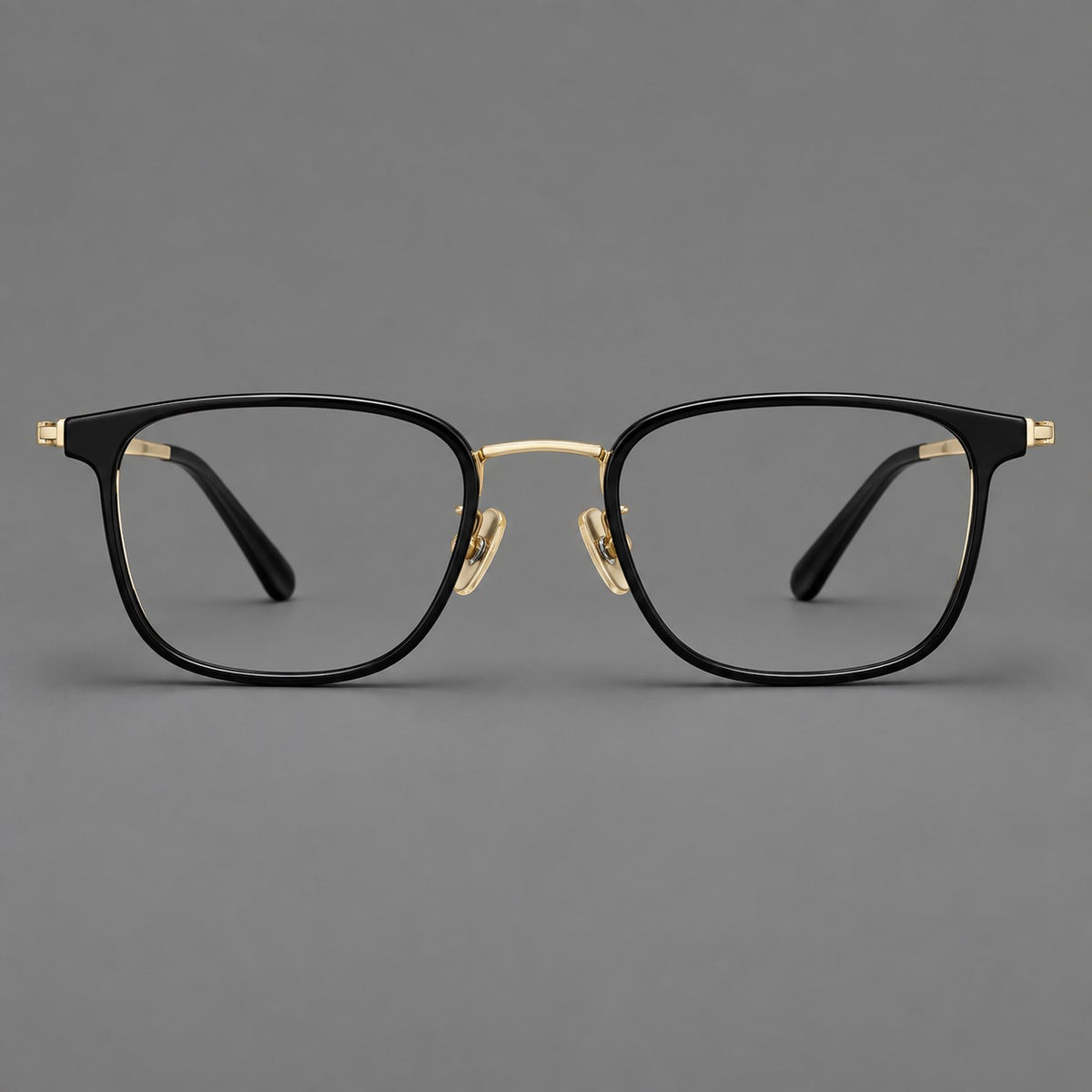 Rounded rectangular eyeglasses in acetate and titanium with bold corners and engraved metal temples in Glossy Black / Gold, front view