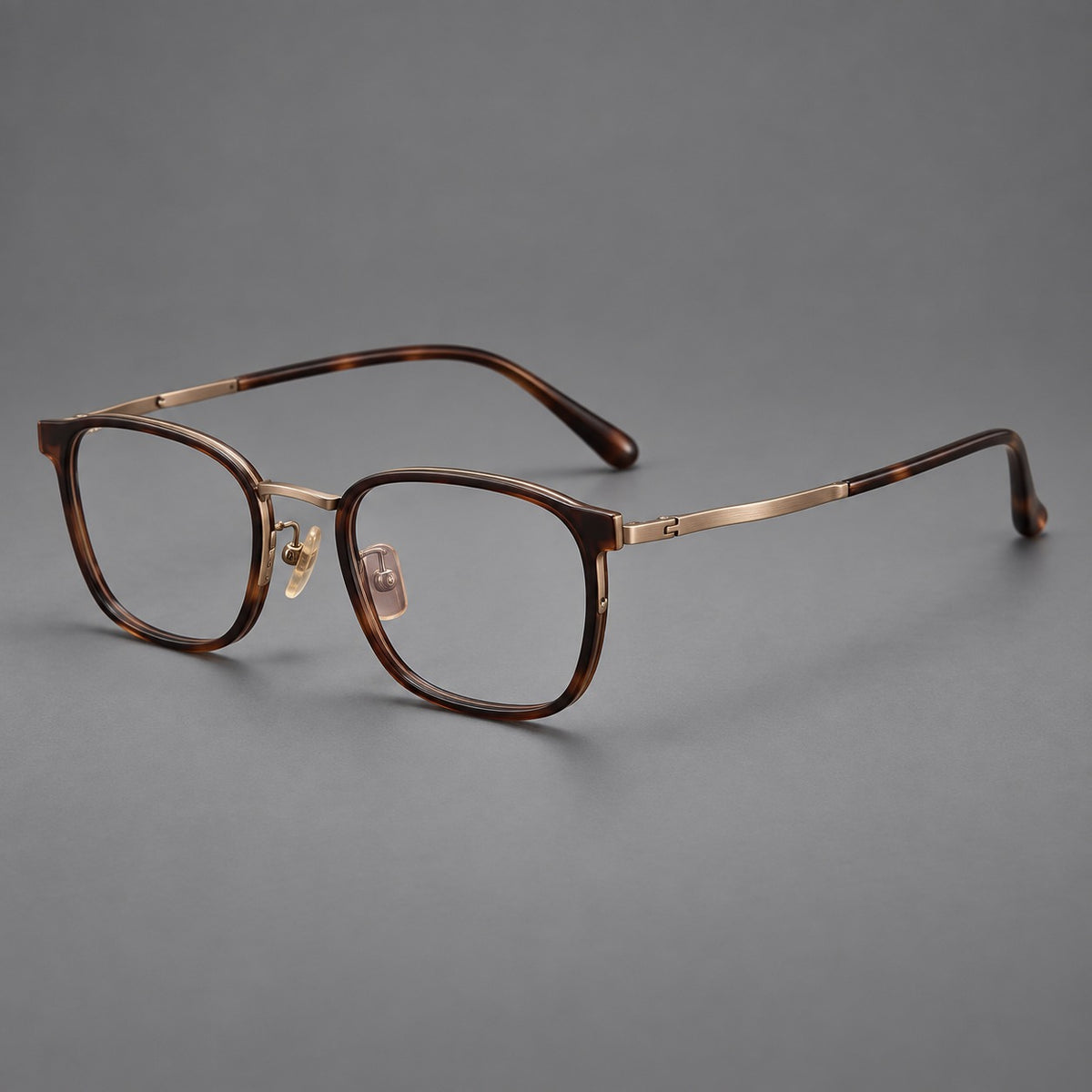 Rounded rectangular eyeglasses in acetate and titanium with bold corners and engraved metal temples in Coffee Brown / Antique Bronze, three quarter view