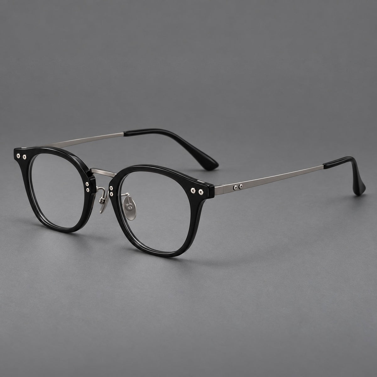 Retro acetate and titanium eyeglasses with softly rounded rims and a metal bridge in Black / Silver, three quarter view