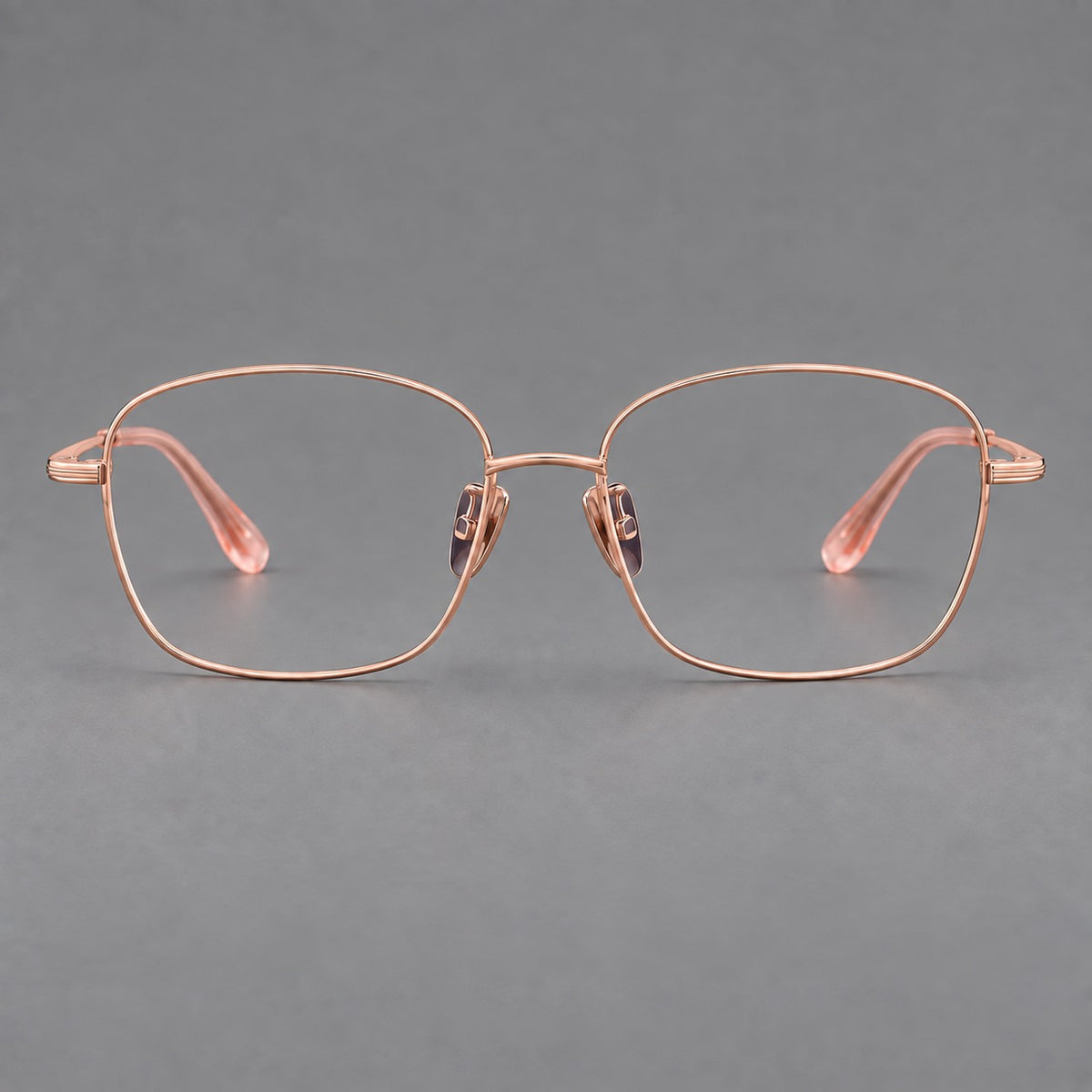 Soft square titanium glasses with angled upper corners and decorated hinges in Rose Gold, front view
