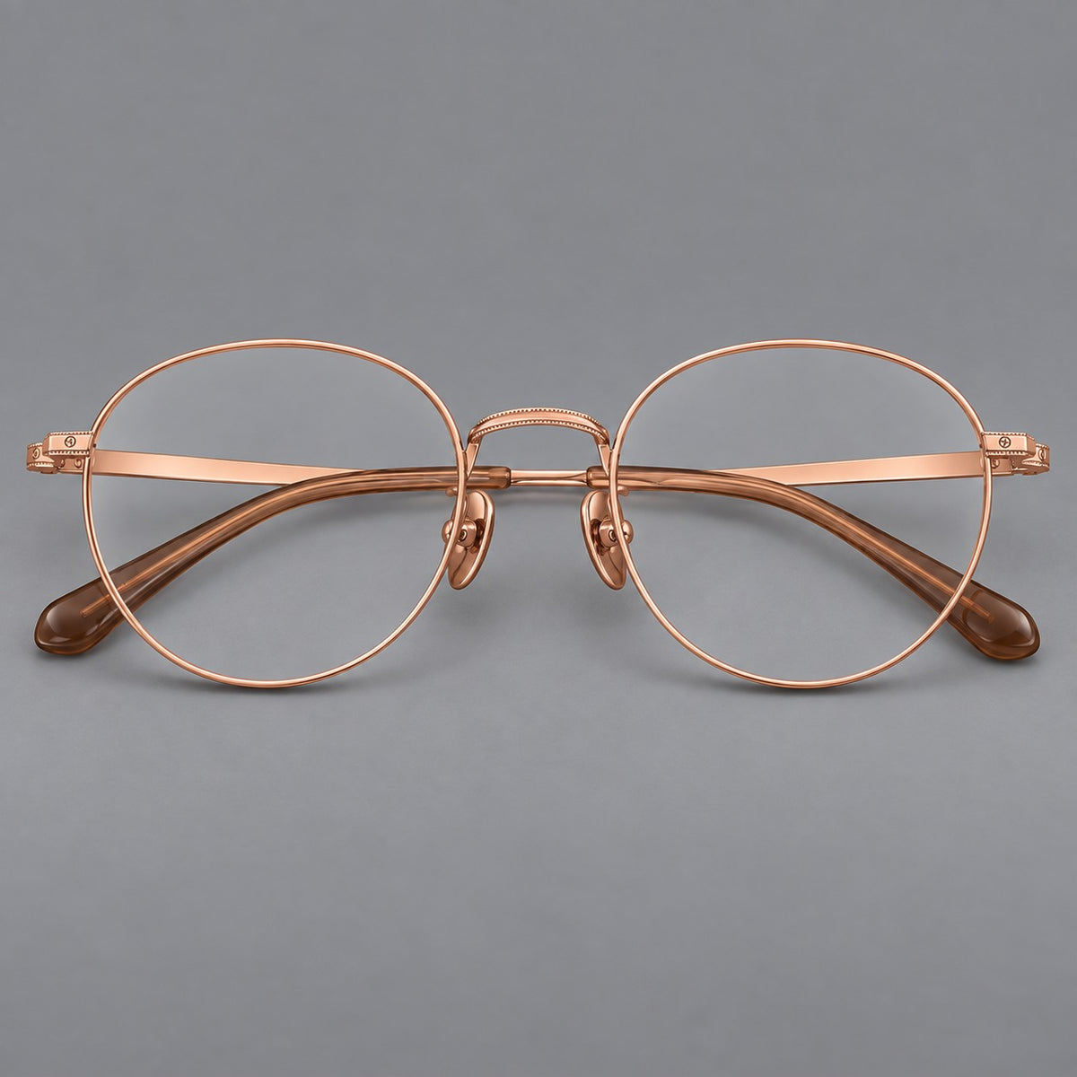 Rounded panto titanium glasses with a raised bridge and dotted temple accents in Rose Gold, front view