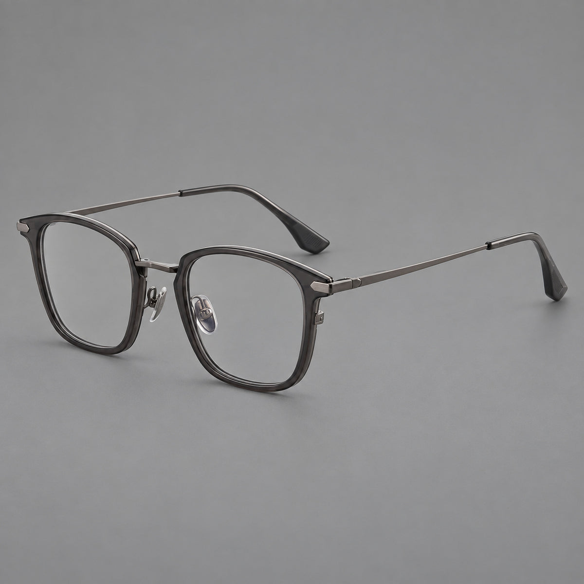 Bold square titanium glasses with a separate bridge and long metal corner accents in Gunmetal, three quarter view