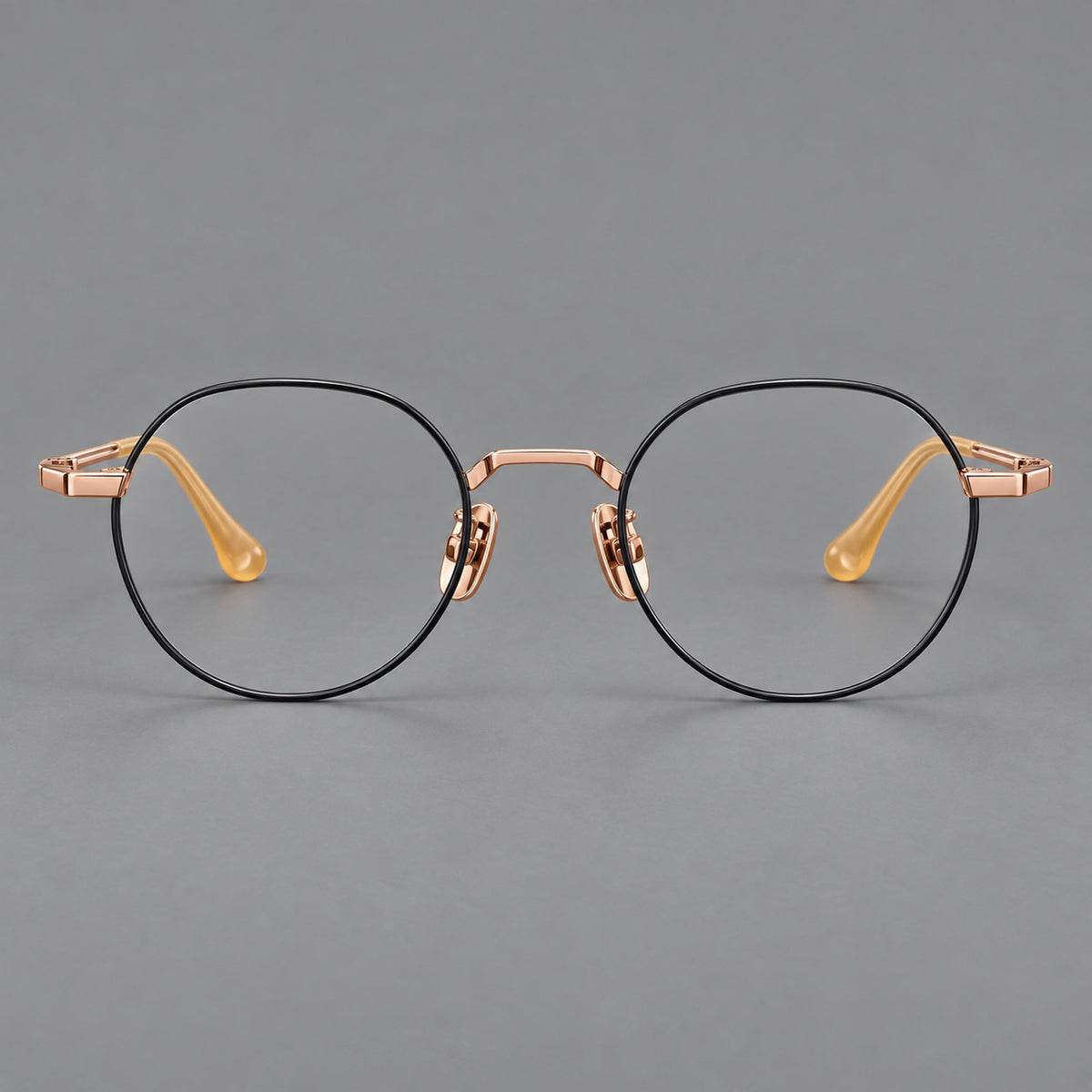 Small panto titanium glasses with an angular bridge and recessed temple details in Black and Rose Gold, front view