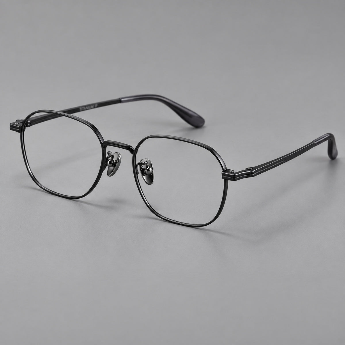 Soft square titanium glasses with an angular bridge and layered corner details in Black, three quarter view
