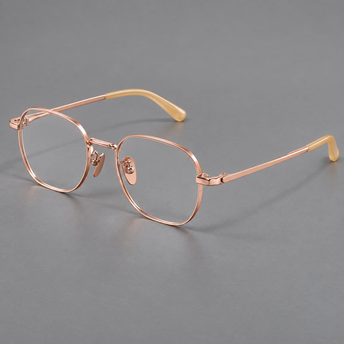 Rounded panto titanium glasses with an angular bridge and broad flat temples in Rose Gold, three quarter view