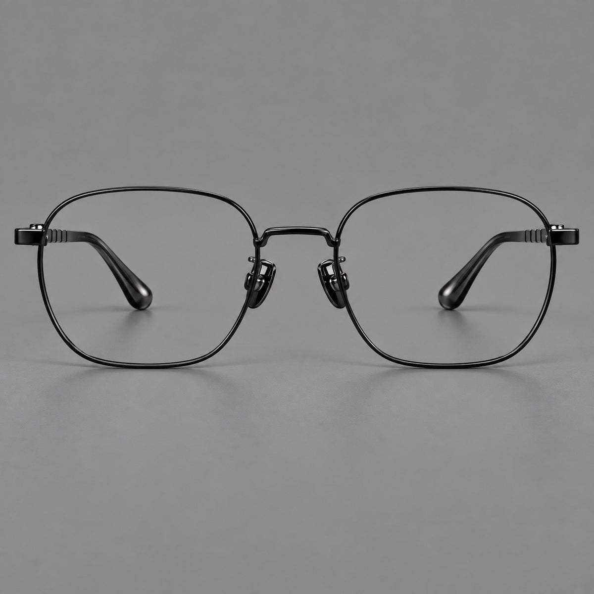 Soft square titanium glasses with a raised bridge and engraved temple bands in Black, front view