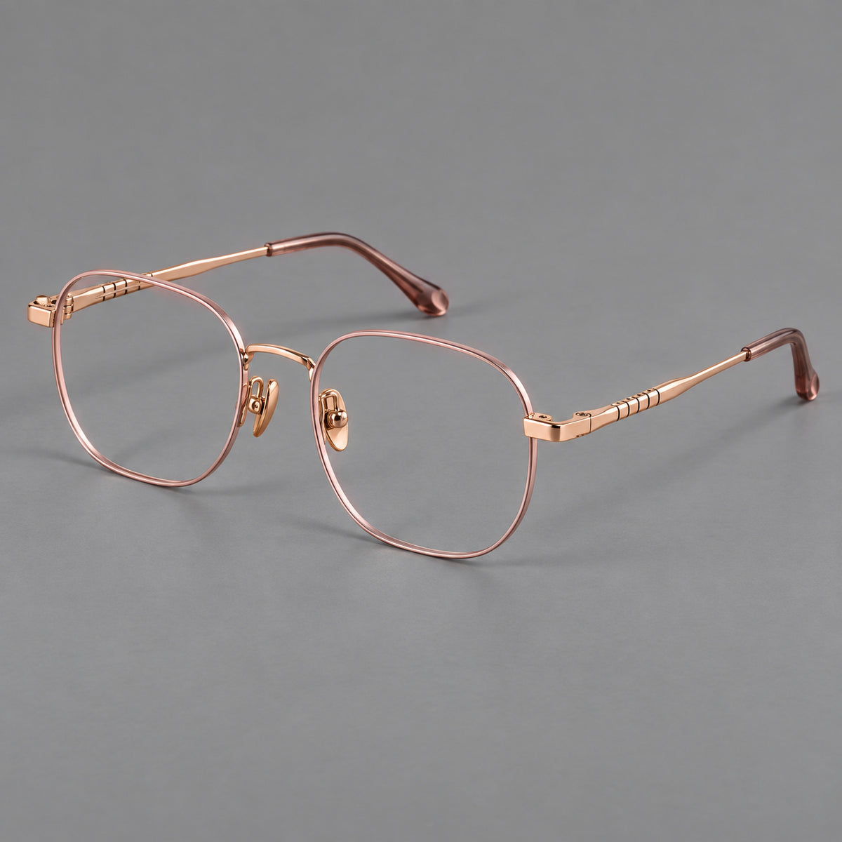 Soft square titanium glasses with a raised bridge and engraved temple bands in Pink and Rose Gold, three quarter view