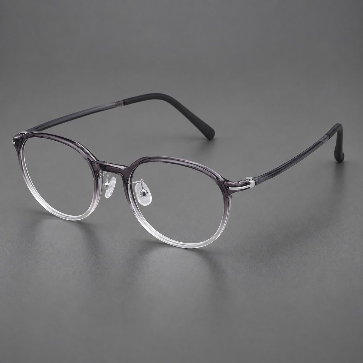 Retro round plastic eyeglasses with a curved bridge and slim metal corner accents in Ink Grey Gradient, three quarter view