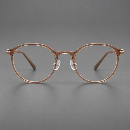 Compact round plastic eyeglasses with gently lifted corners and clear nose pads in Amber Tea, front view temple detail
