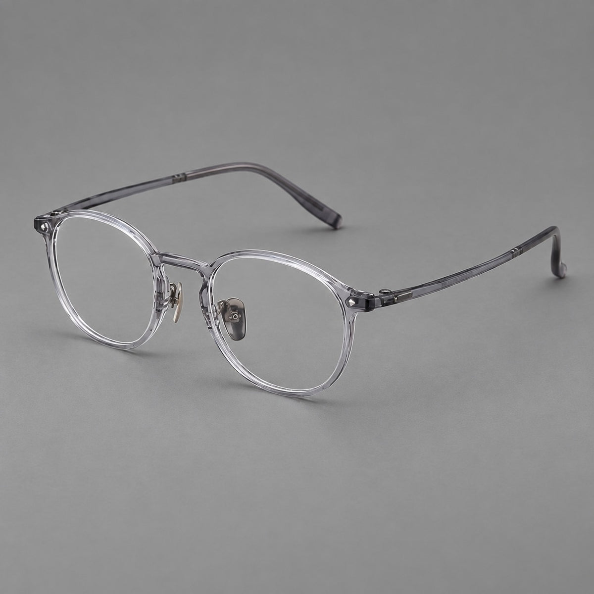 Vintage round plastic eyeglasses with a curved bridge and subtle triangular accents in Light Grey, three quarter view