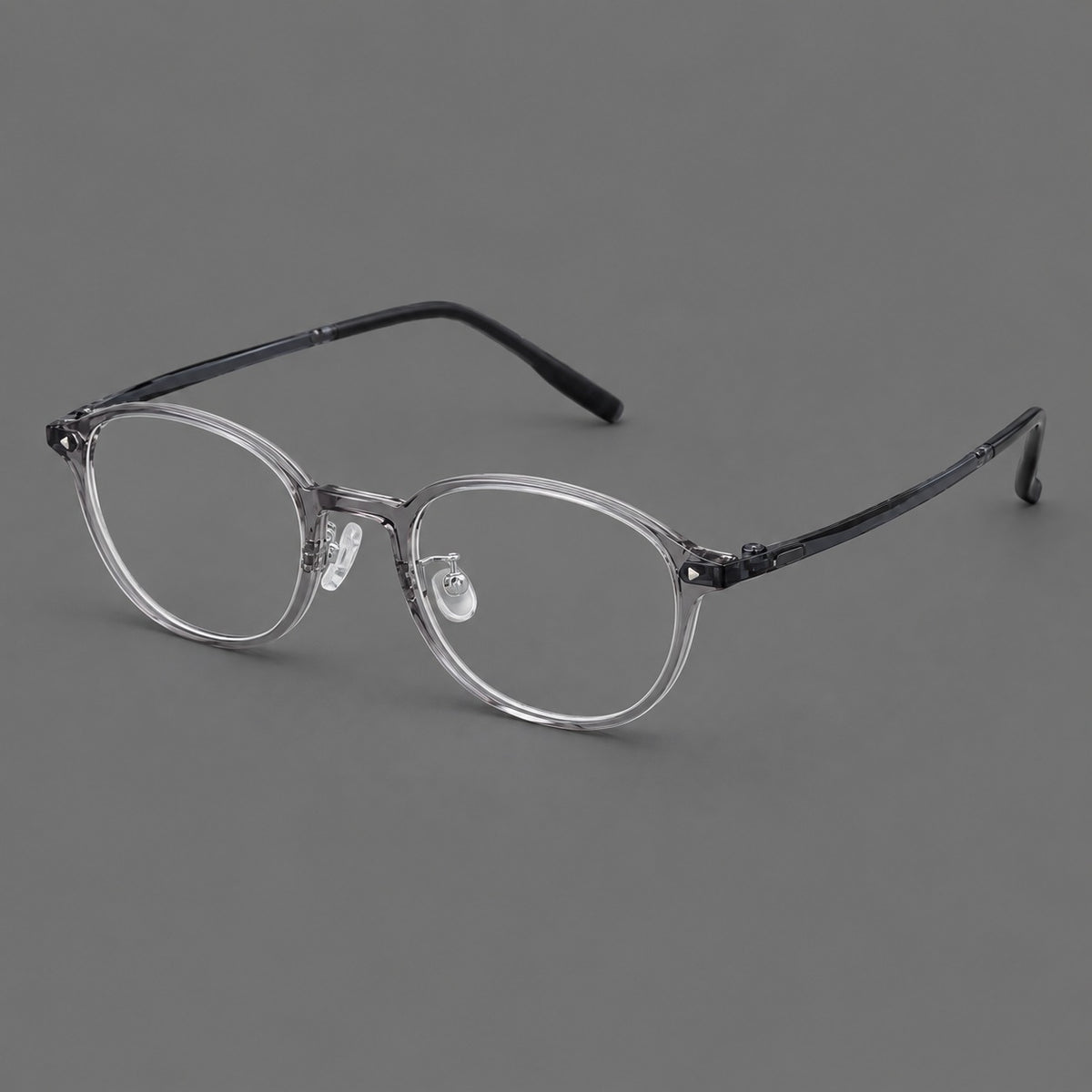 Panto plastic eyeglasses with a rounded silhouette and triangular corner studs in Grey, three quarter view