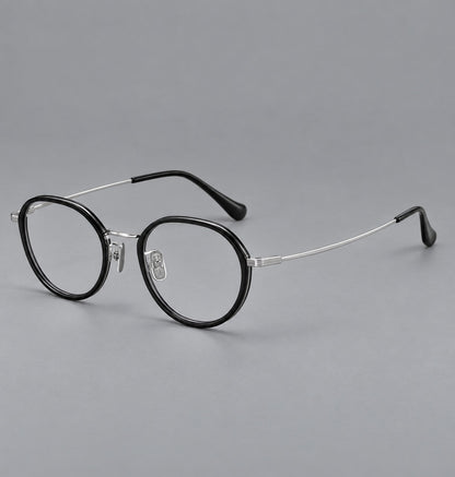 Rounded eyeglasses in acetate and titanium with gently arched brows and engraved metal temples in Black / Silver, three quarter view additional product view