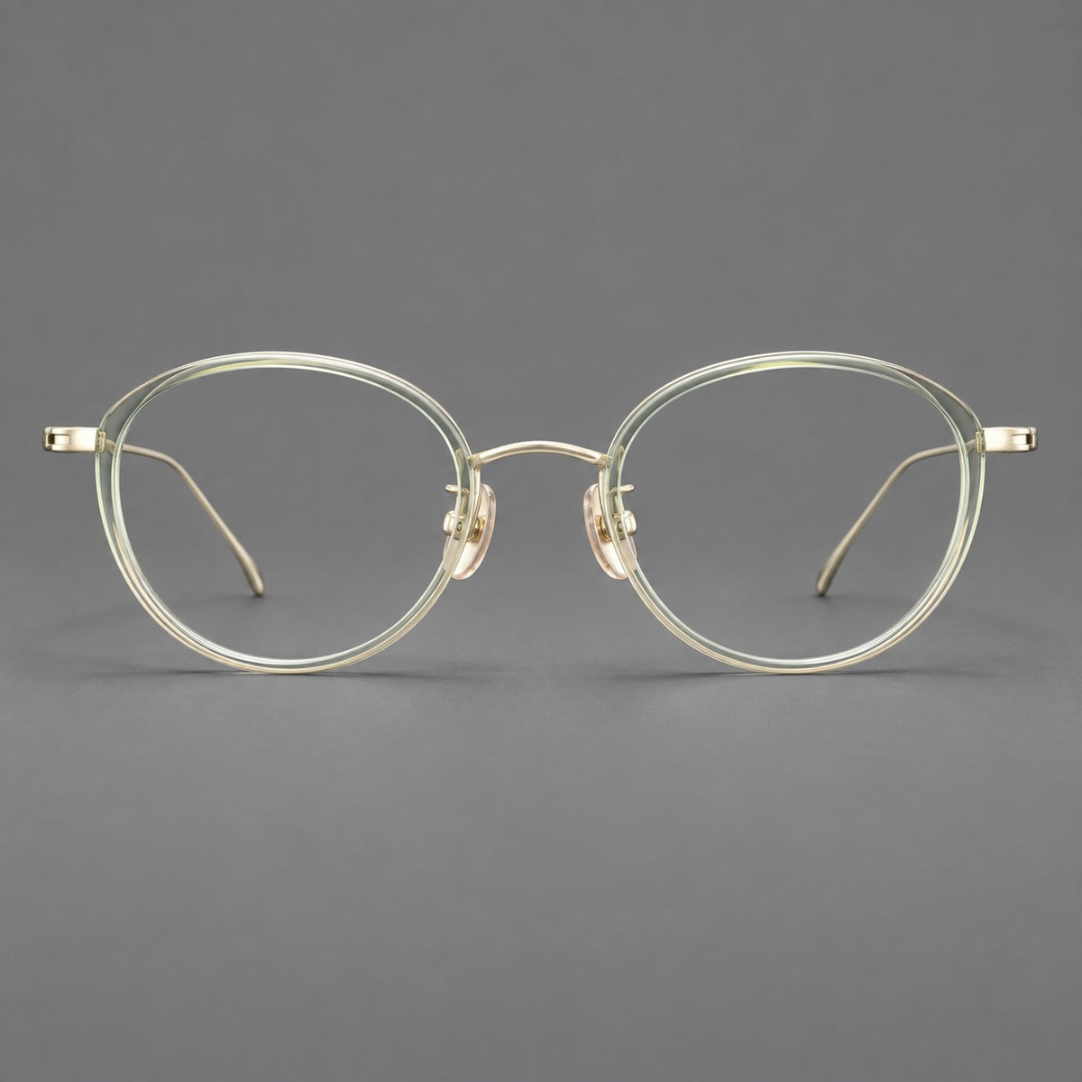 Round eyeglasses in acetate and titanium with a slim curved bridge and fine metal temples in Green / Gold, front view
