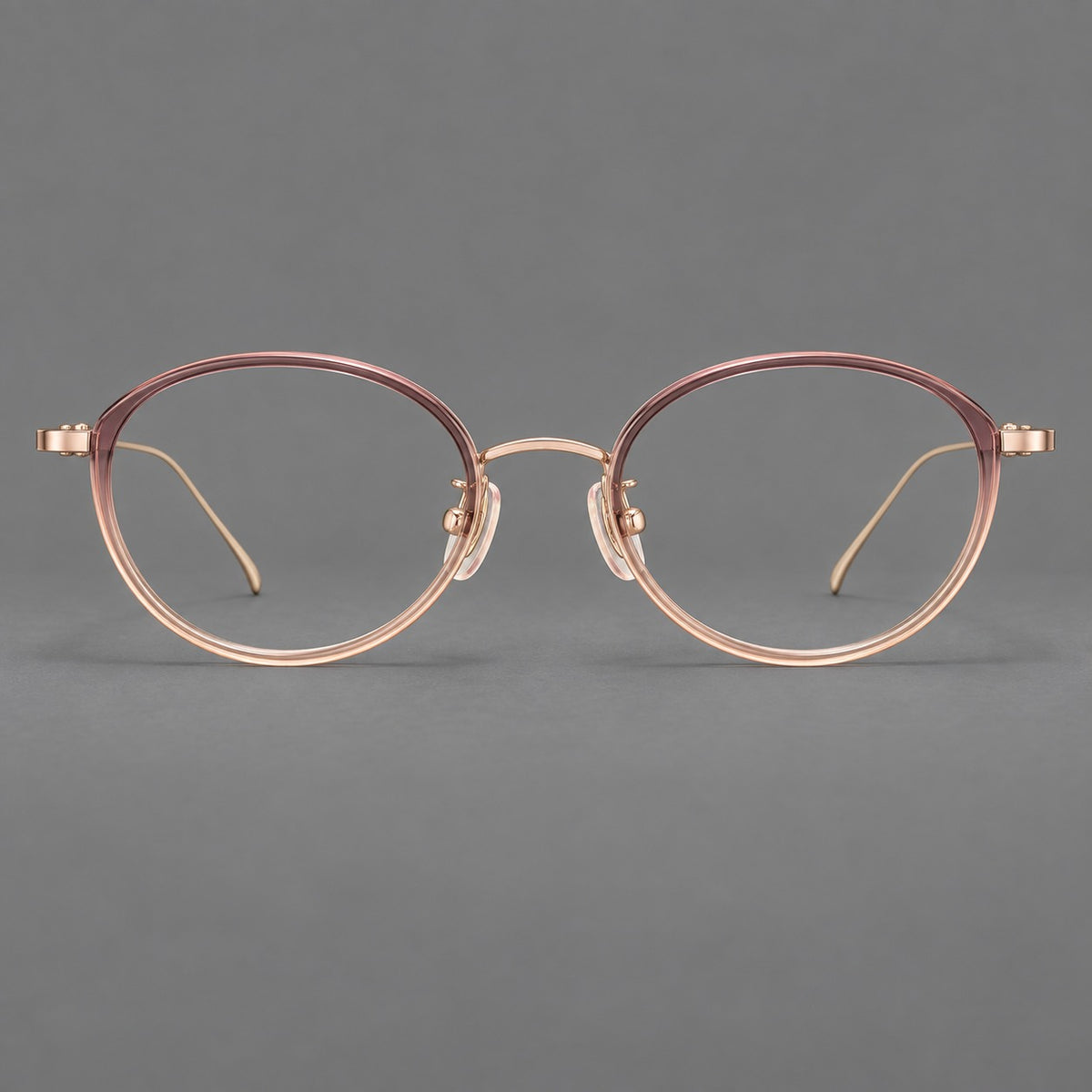Round eyeglasses in acetate and titanium with a slim curved bridge and fine metal temples in Pink Tea Gradient / Rose Gold, front view