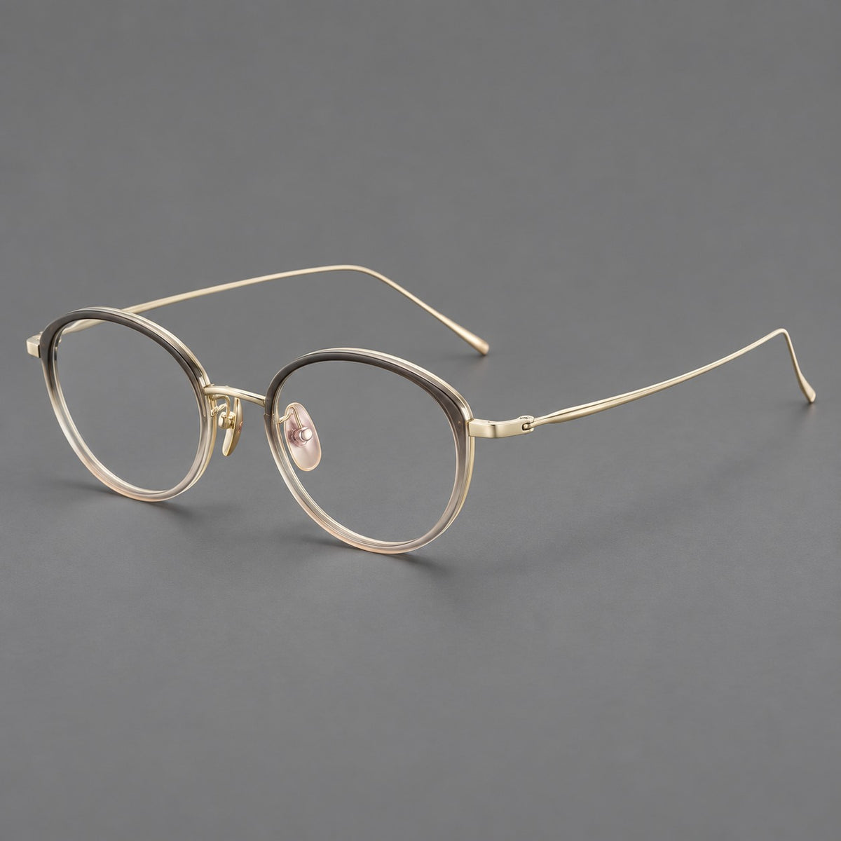 Round eyeglasses in acetate and titanium with a slim curved bridge and fine metal temples in Grey Tea Gradient / Gold, three quarter view