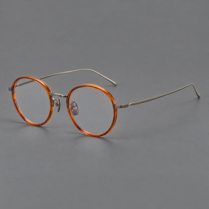 Classic round eyeglasses in acetate and titanium with slim rims and textured metal temples in Tea Brown / Gunmetal, three quarter view