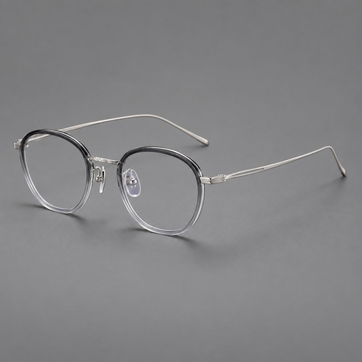 Vintage round eyeglasses in acetate and titanium with an engraved bridge and slender temples in Grey Gradient / Silver, three quarter view
