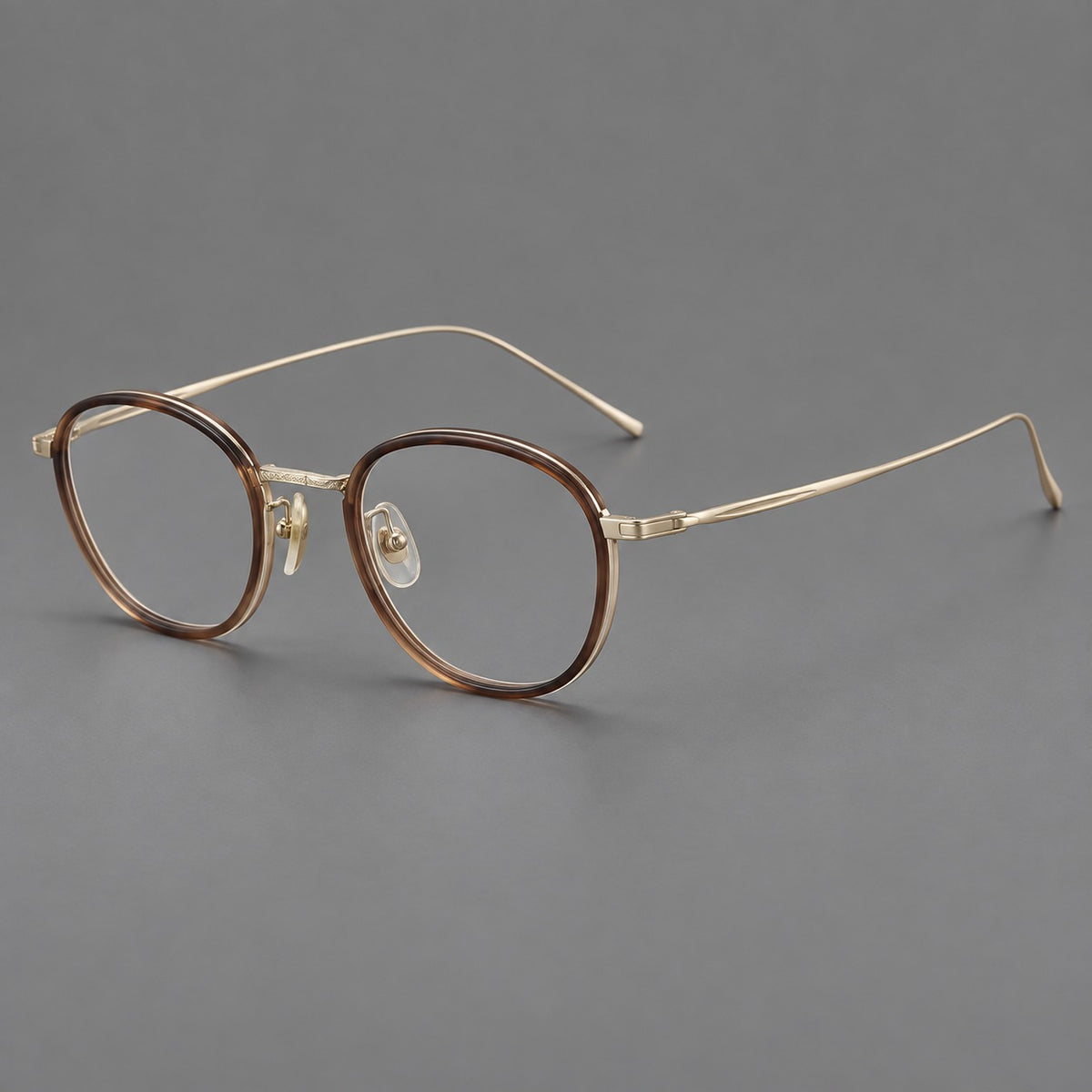 Vintage round eyeglasses in acetate and titanium with an engraved bridge and slender temples in Tea Gradient / Light Gold, three quarter view