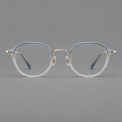 Softly rounded eyeglasses in acetate and titanium with a curved bridge and engraved temples in Ice Blue Grey / Gold, front view side view