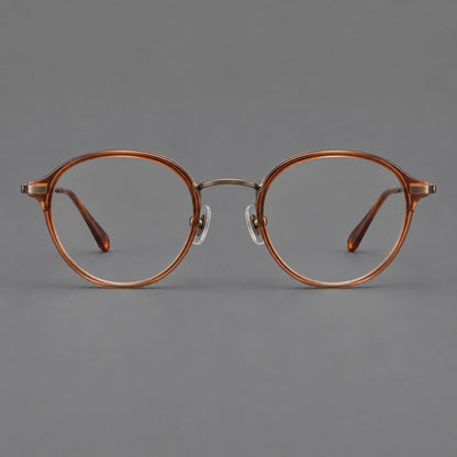 Softly rounded eyeglasses in acetate and titanium with a curved bridge and engraved temples in Tea Brown / Antique Bronze, front view frame detail