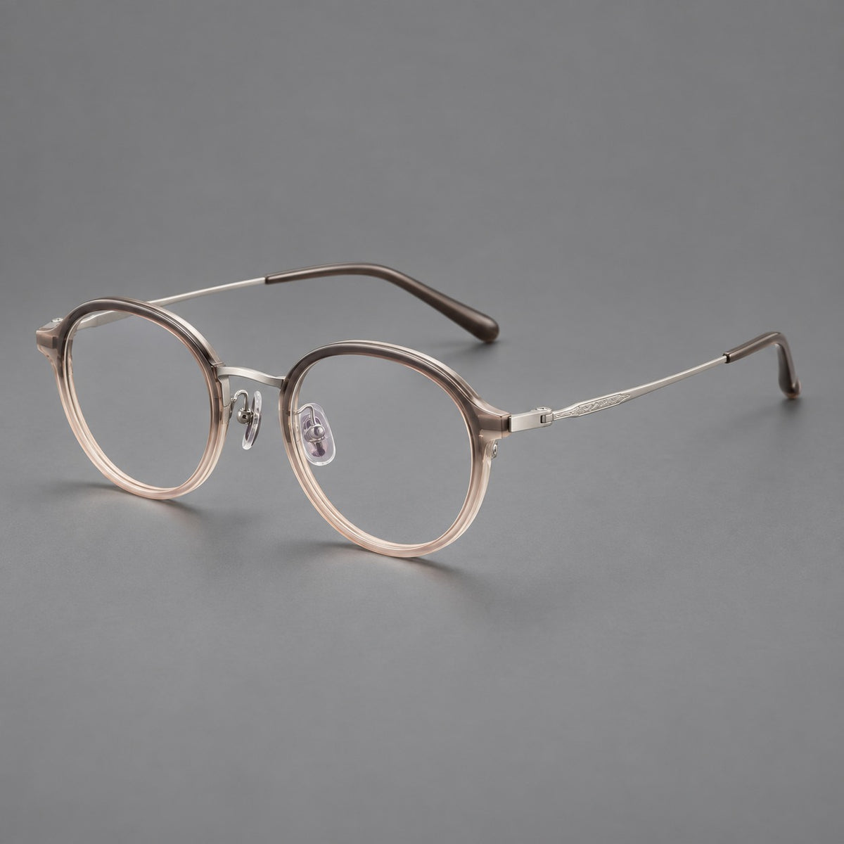 Softly rounded eyeglasses in acetate and titanium with a curved bridge and engraved temples in Tea Pink Gradient / Silver, three quarter view