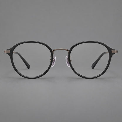 Softly rounded eyeglasses in acetate and titanium with a curved bridge and engraved temples in Matte Black / Antique Copper, front view additional product view