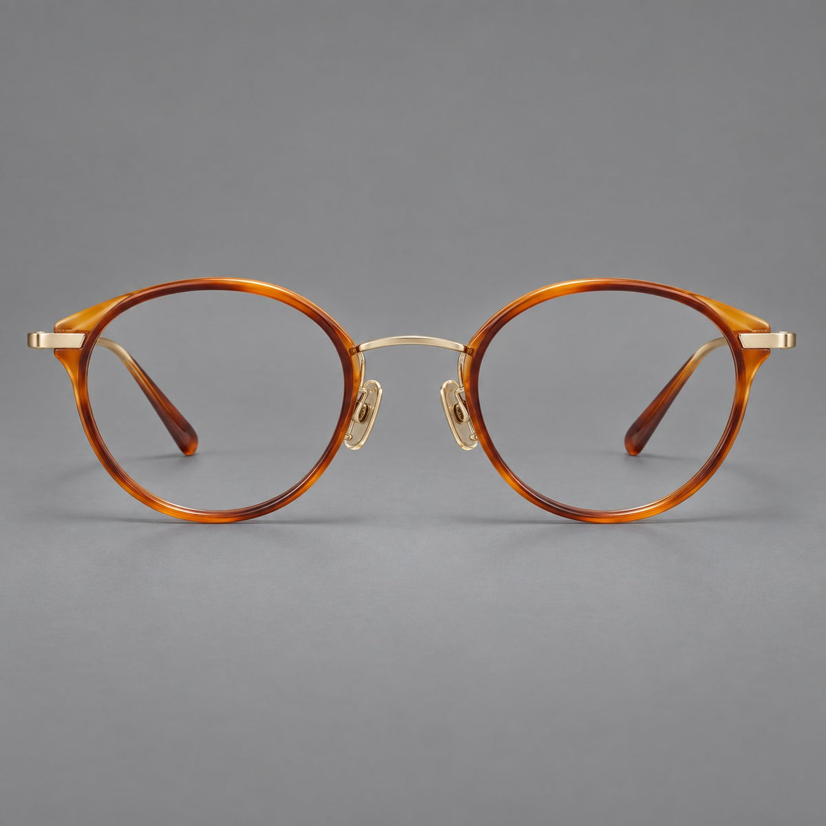 Retro panto eyeglasses in acetate and titanium with an arched bridge and engraved metal temples in Amber Tortoiseshell / Light Gold, front view