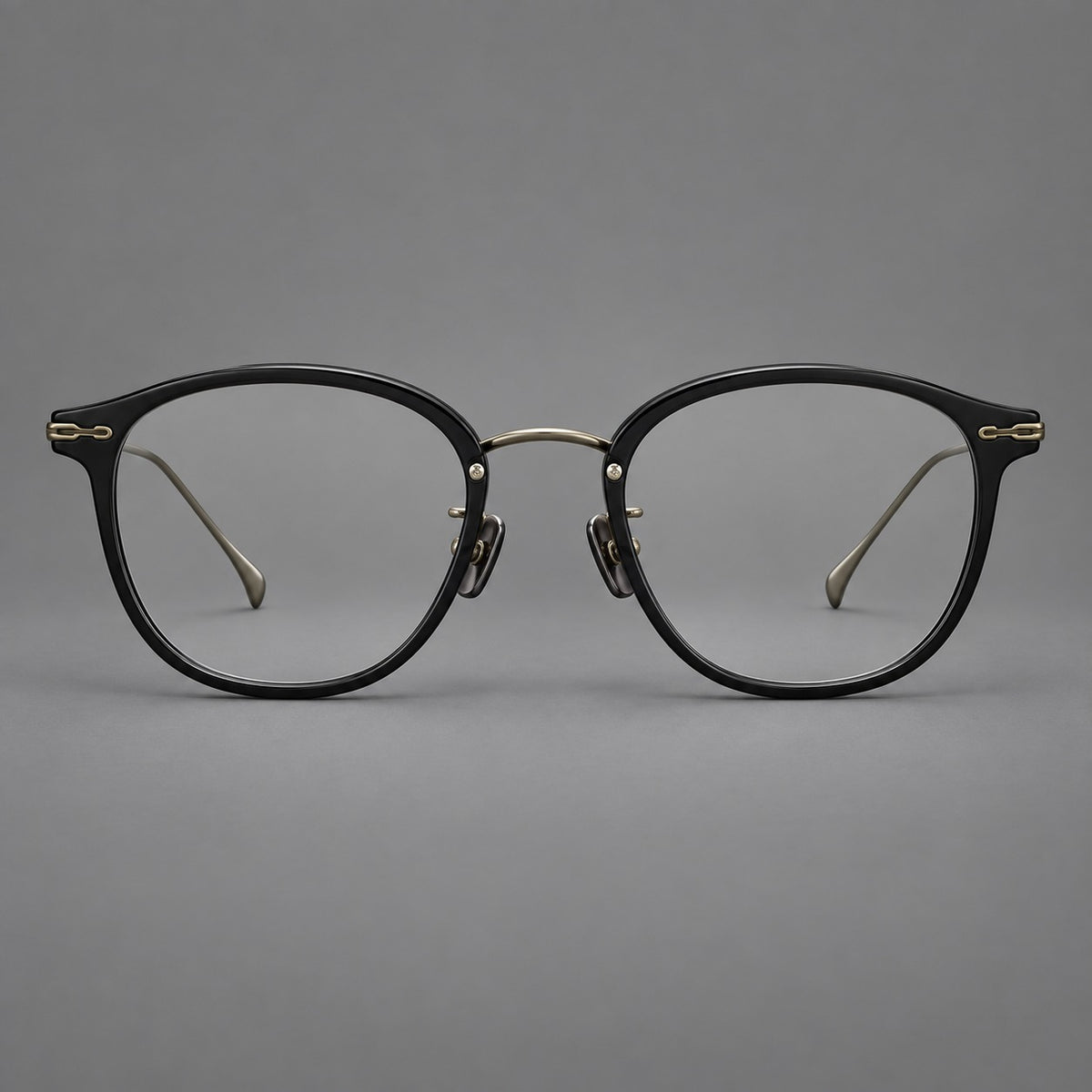 Panto eyeglasses in acetate and titanium with curved brows and decorative metal corner accents in Glossy Black / Antique Bronze, front view