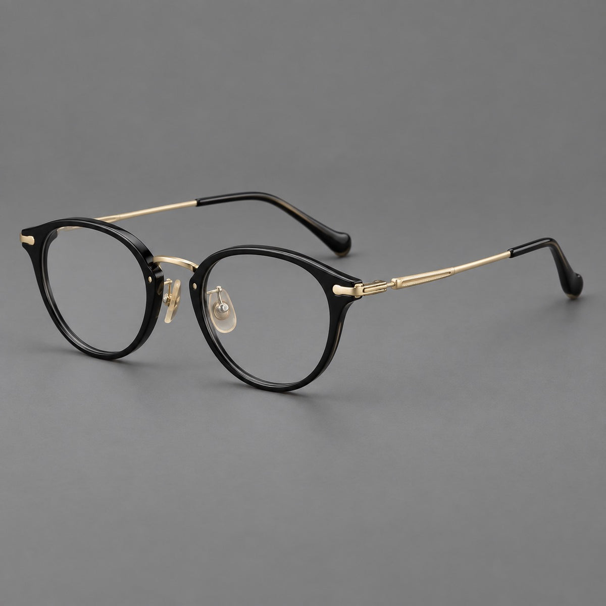 Vintage panto eyeglasses in acetate and titanium with raised brows and textured metal temples in Glossy Black / Gold, three quarter view