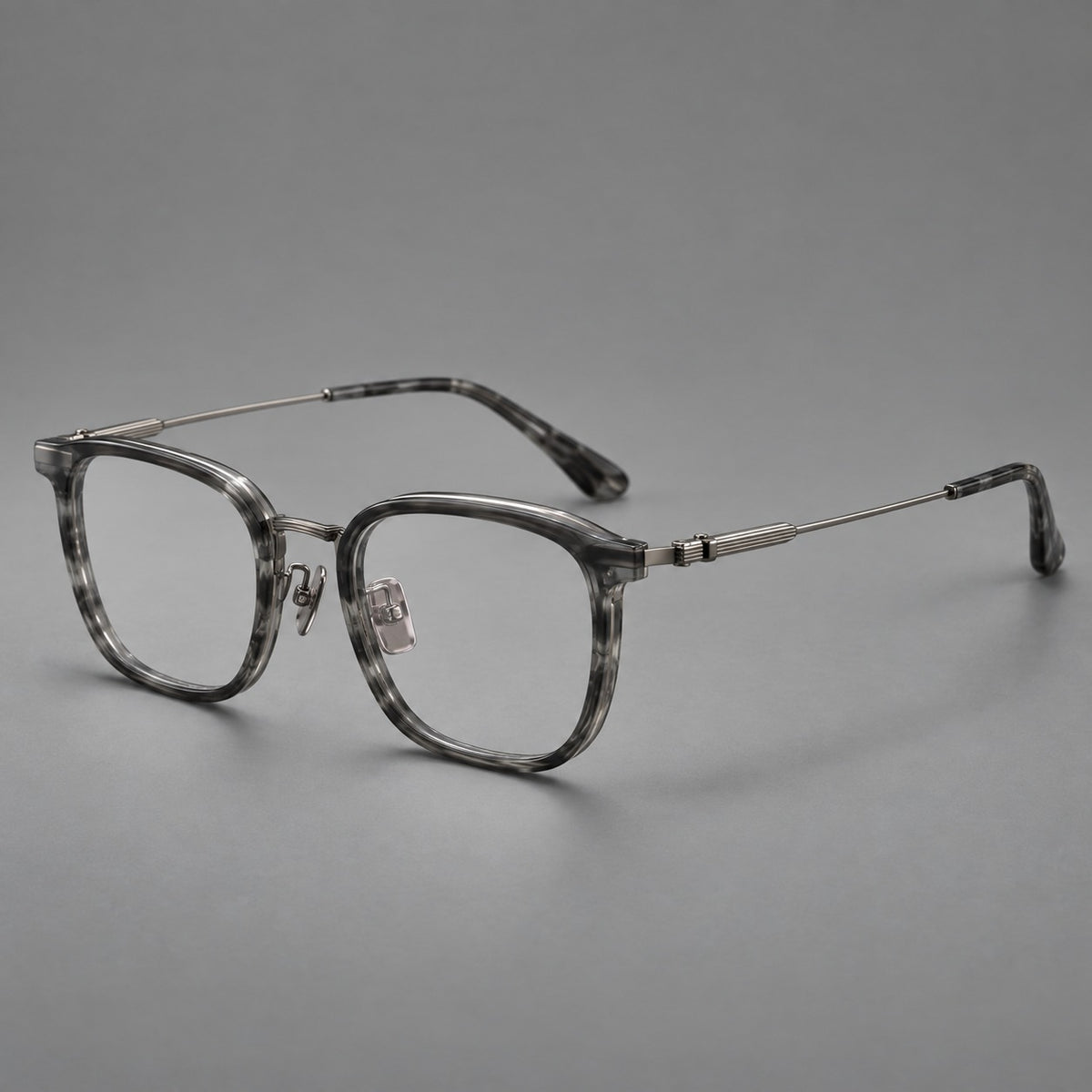 Soft square eyeglasses in acetate and titanium with wide upper corners and fine metal temples in Marbled Grey / Gunmetal, three quarter view