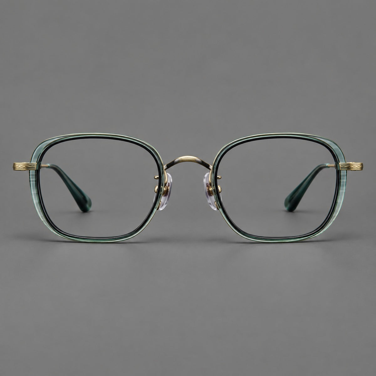 Rounded square eyeglasses in acetate and titanium with an arched bridge and engraved temples in Misted Clear Green / Antique Gold, front view