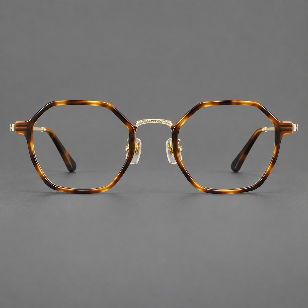 Geometric eyeglasses in acetate and titanium with octagonal rims and a textured metal bridge in Amber Tortoiseshell / Light Gold, front view