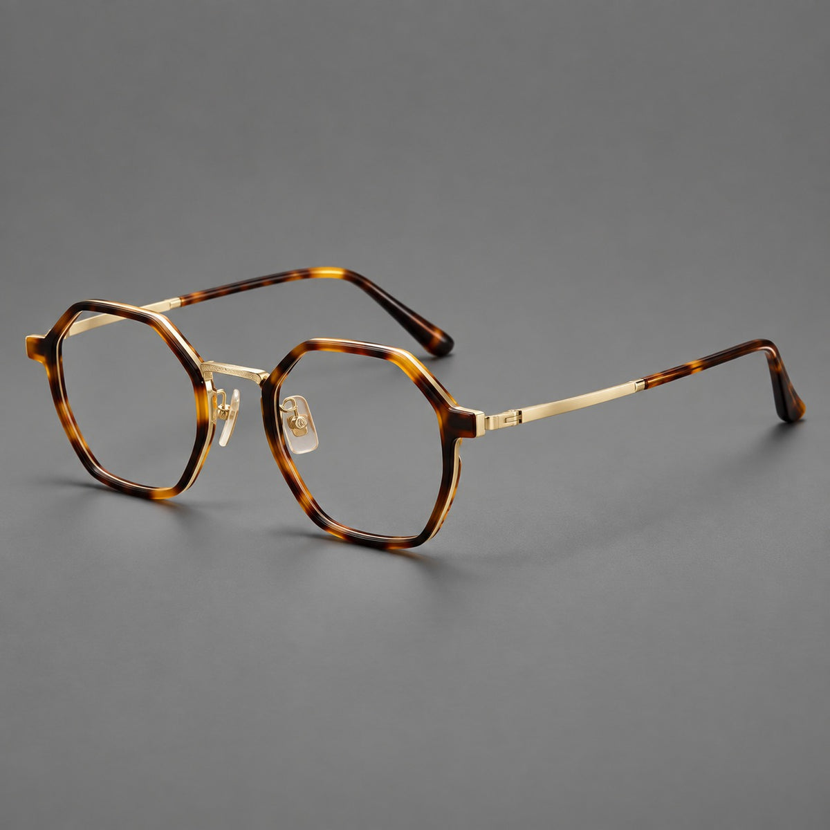 Geometric eyeglasses in acetate and titanium with octagonal rims and a textured metal bridge in Amber Tortoiseshell / Light Gold, three quarter view
