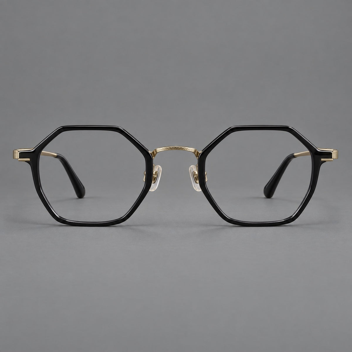 Geometric eyeglasses in acetate and titanium with octagonal rims and a textured metal bridge in Glossy Black / Antique Gold, front view