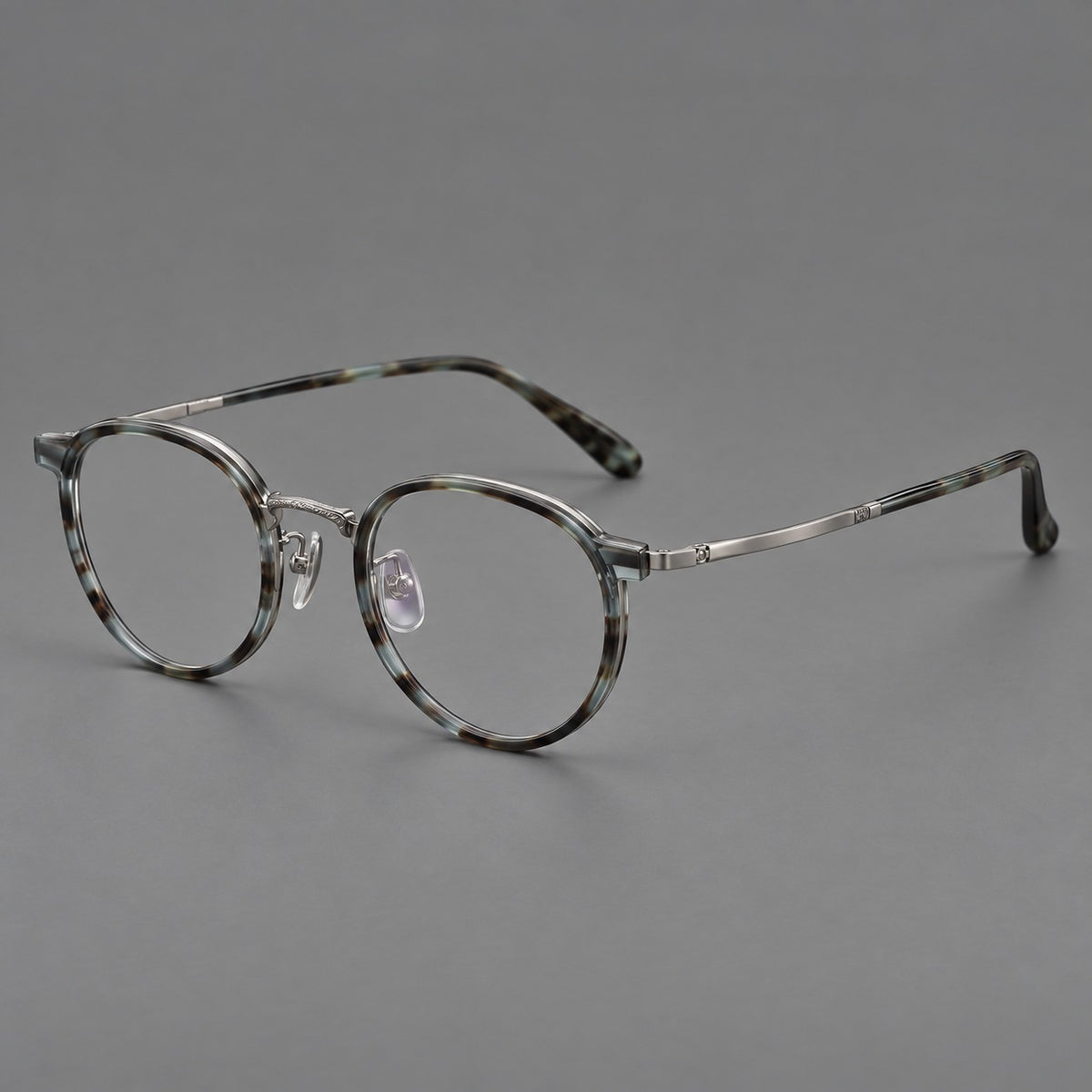 Round eyeglasses in acetate and titanium with widened outer corners and slender metal temples in Green Grey Tortoiseshell / Gunmetal, three quarter view