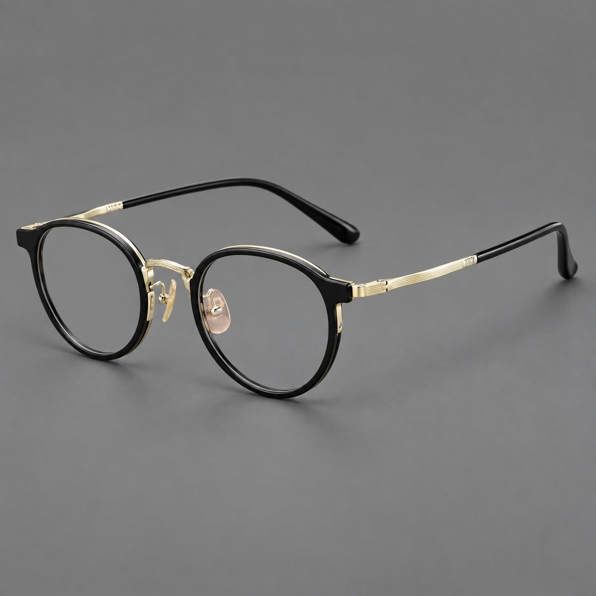 Round eyeglasses in acetate and titanium with widened outer corners and slender metal temples in Glossy Black / Gold, three quarter view