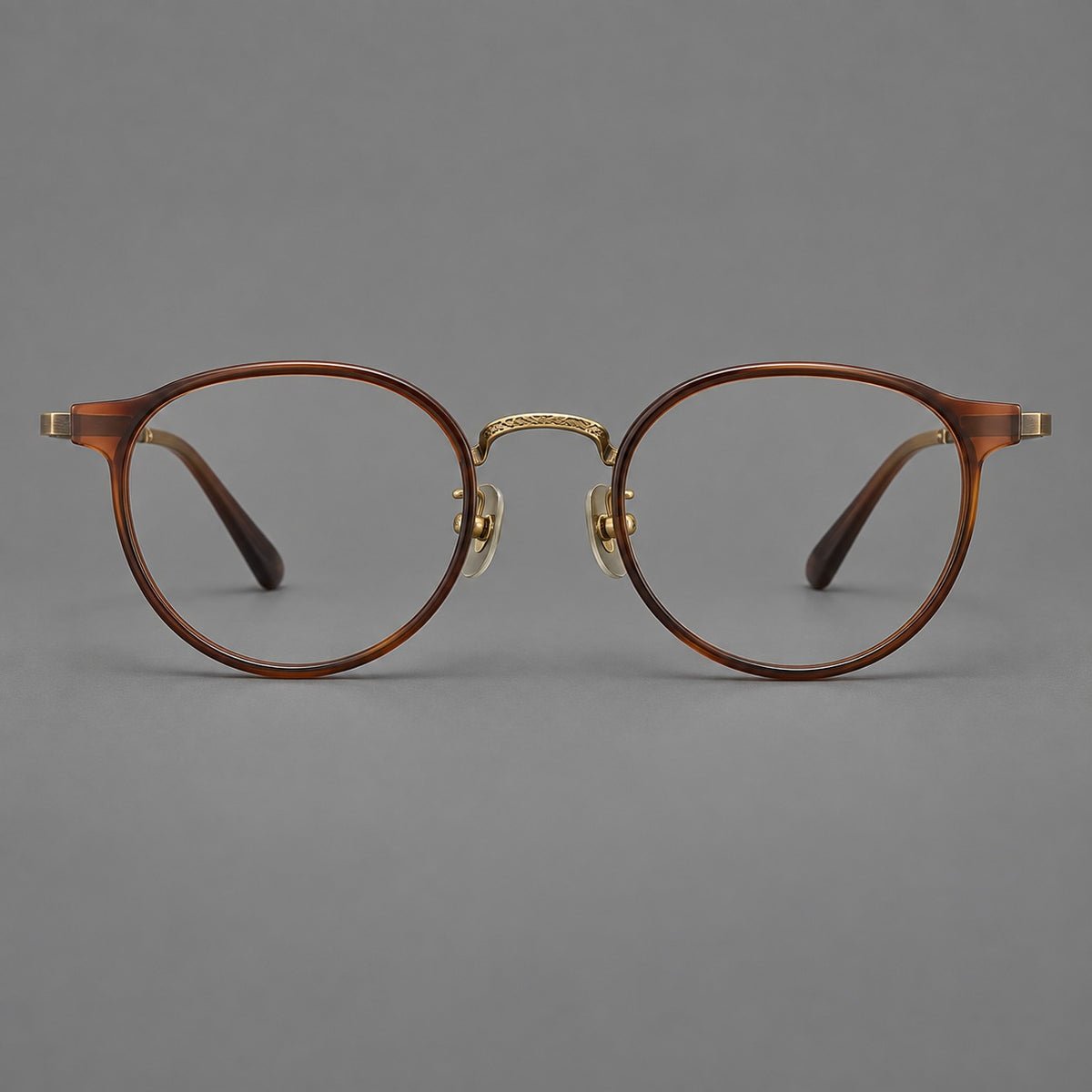 Round eyeglasses in acetate and titanium with widened outer corners and slender metal temples in Coffee Brown / Antique Bronze, front view