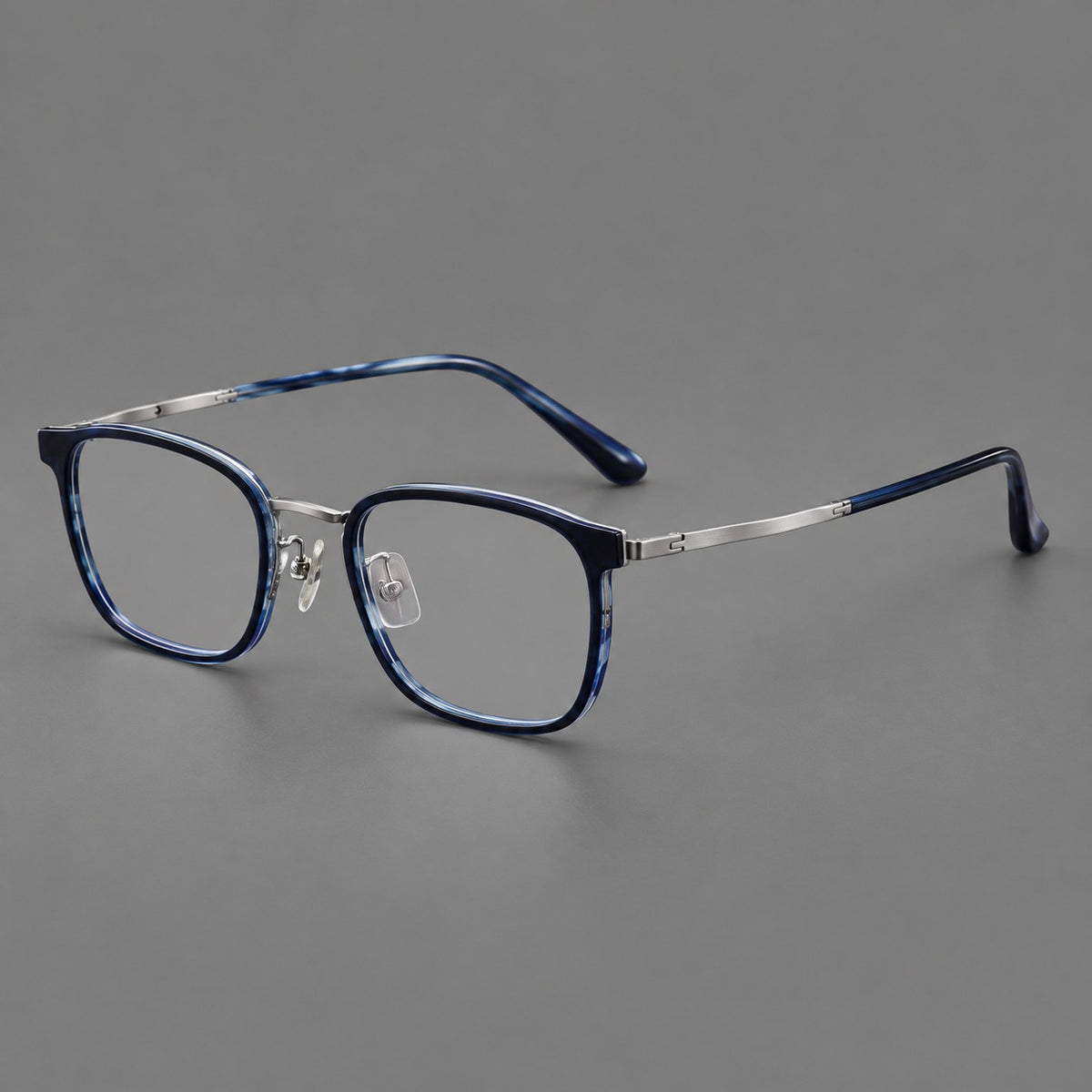 Rounded rectangular eyeglasses in acetate and titanium with bold corners and engraved metal temples in Blue / Gunmetal, three quarter view