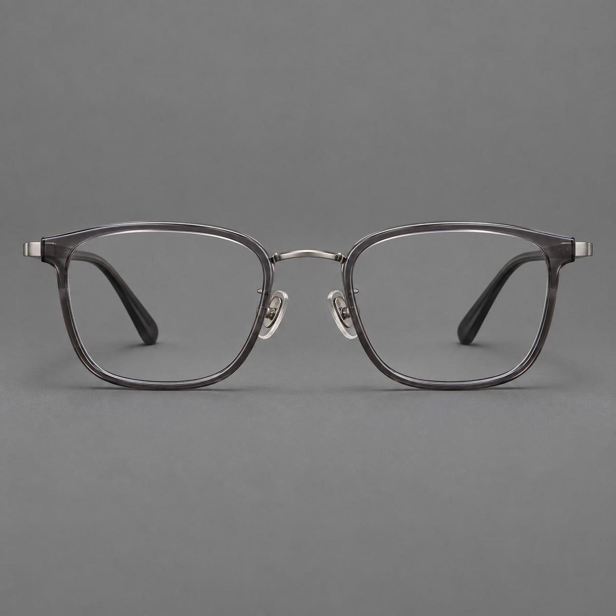 Rounded rectangular eyeglasses in acetate and titanium with bold corners and engraved metal temples in Clear Grey / Gunmetal, front view